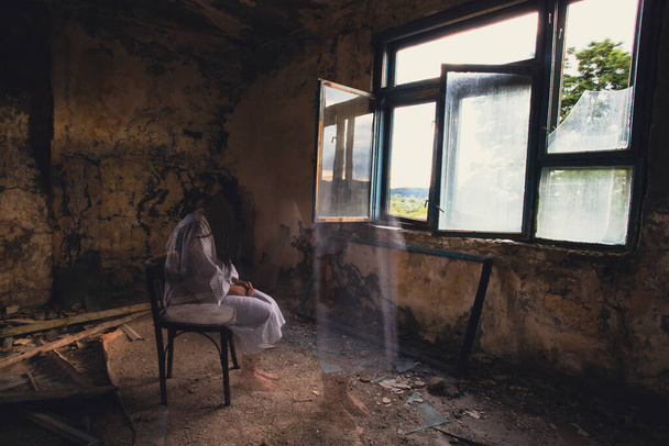 Ghost in abandoned, haunted house. Horror scene of scary spirit of a woman, halloween concept. - Foto, immagini