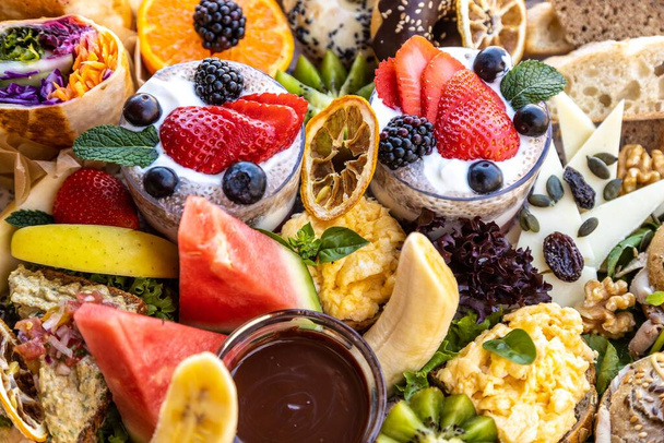 A closeup of assorted fruits, cheese, bread, and dessert on a platter - Φωτογραφία, εικόνα