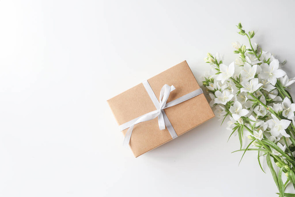 Cardboard gift box with a bow and flowers on a white background - Photo, Image
