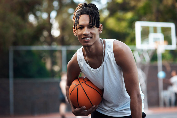 Be hard to play against, but easy to play with. Portrait of a sporty young man standing on a basketball court - Foto, imagen