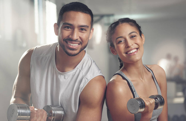 Working out makes us happy. two young athletes holding dumbbells - Photo, image