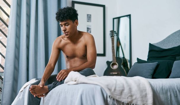 Whats up with this foot pain. a young man waking up with foot pain at home - Fotoğraf, Görsel