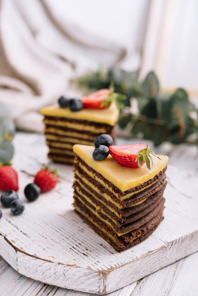 Вкусный свежий шоколадный торт с ягодами на деревянном столе
 - Фото, изображение