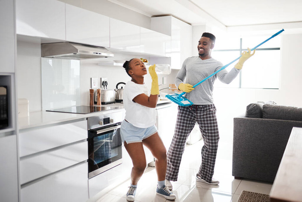 Τίποτα δεν κάνει έναν γάμο να λάμπει όσο η καλή, καθαρή διασκέδαση. ένα ευτυχισμένο νεαρό ζευγάρι που διασκεδάζει καθαρίζοντας την κουζίνα στο σπίτι - Φωτογραφία, εικόνα