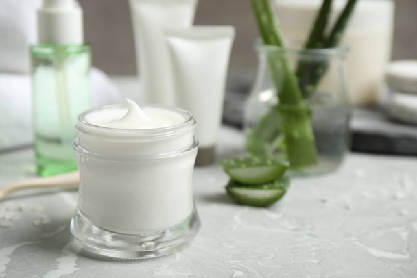 Open jar of aloe cream on grey marble table. Organic cosmetics - Фото, зображення
