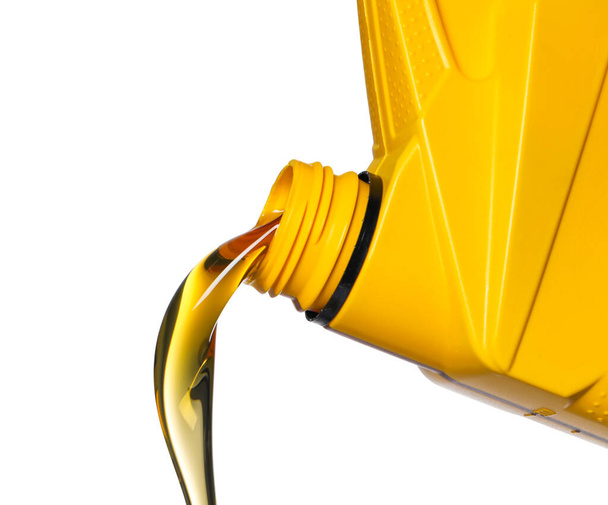 Pouring motor oil from yellow container on white background, closeup - Foto, Bild