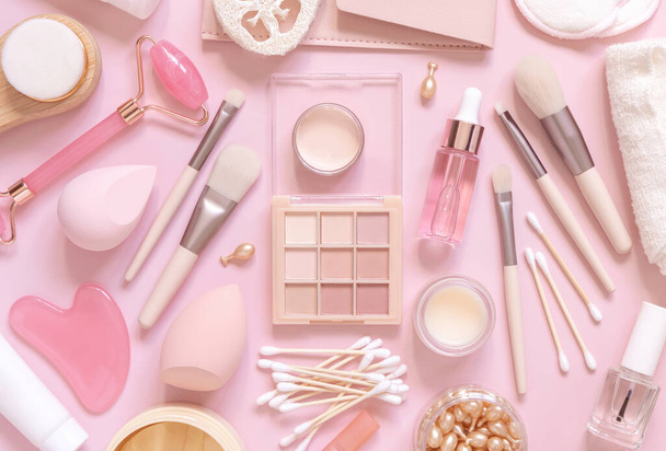 Skin care and makeup products on light pink, top view, banner. Flat lay with natural beauty products and decorative cosmetics. Everyday woman face care routine. Pastel composition - Photo, image