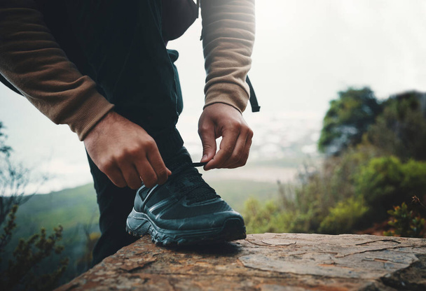 Выходные для походов. Крупный план неузнаваемого человека, завязывающего шнурки во время прогулки - Фото, изображение