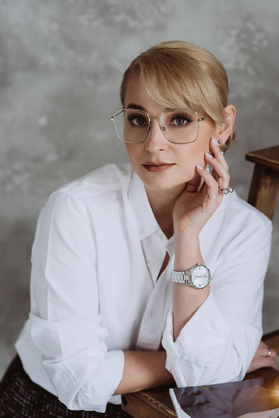 Beautiful middle aged business woman in glasses standing over isolated white background with a happy and cool smile on her face. Happy man. Soft selective focus. - Valokuva, kuva