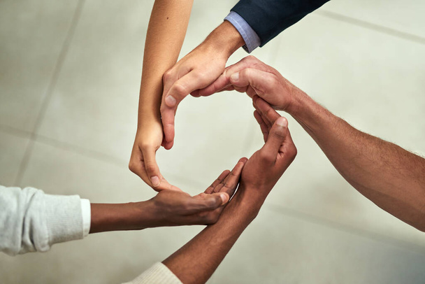 Group of businesspeople hands making creative circle shape together in an office at work. Above diverse business professionals support, motivate and unity during a meeting in a corporate office. - Fotó, kép