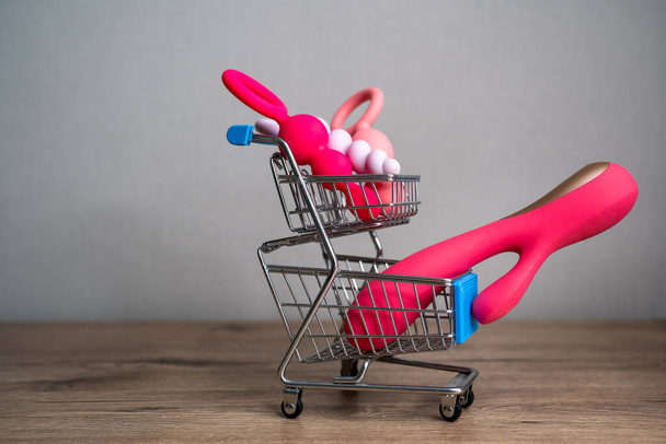 supermarket trolley filled with sex toys vibrator and anal butt plugs. Concept of buying adult toys, e shopping  - 写真・画像
