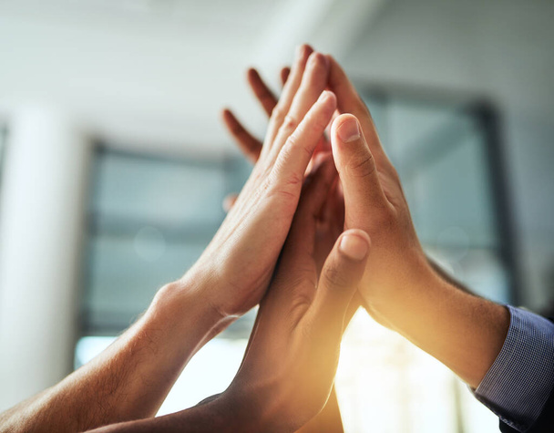 High five of a diverse group of businesspeople celebrate, unite and support each other. Closeup of a multiethnic corporate professional team hands touching showing success inside a startup office. - Foto, Bild