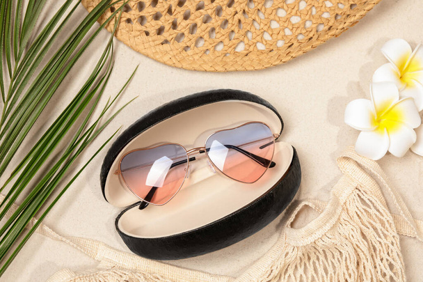 Flat lay composition with stylish sunglasses in black leather case on sand - Φωτογραφία, εικόνα