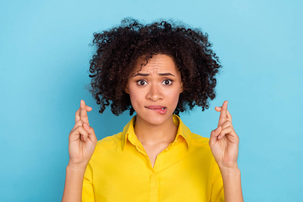 Portrait of attractive panicking lady crossed fingers biting lip wear smart casual isolated on blue color background. - Foto, imagen