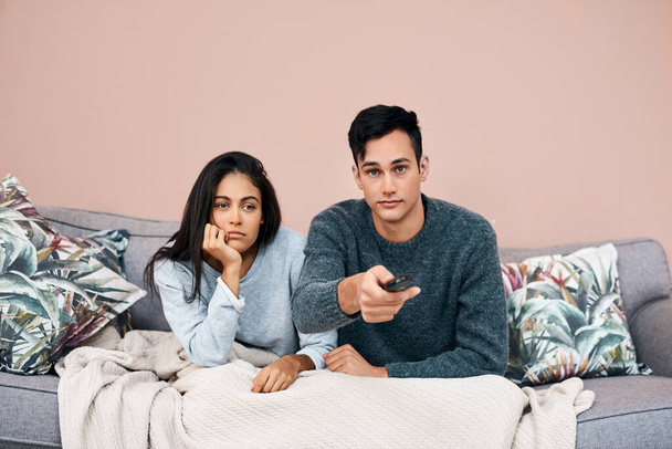 Some breaking news will clear that boredom right up. a young couple watching tv while recovering from an illness at home - Foto, Imagen