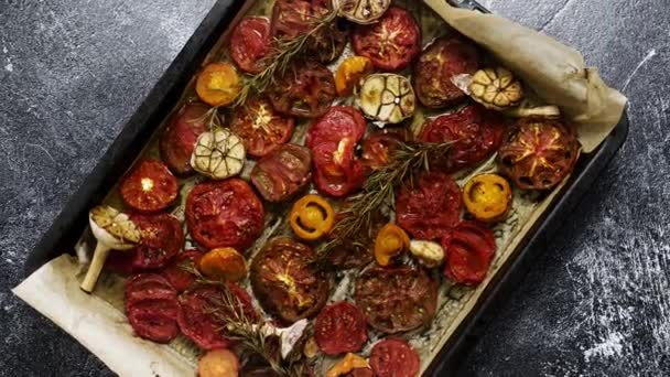 Various kinds of roasted red and yellow tomatoes with thyme and garlic on an metal oven tray. Top view, flat lay - Πλάνα, βίντεο