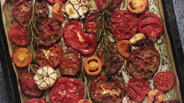 Various kinds of roasted red and yellow tomatoes with thyme and garlic on an metal oven tray. Top view, flat lay - Πλάνα, βίντεο