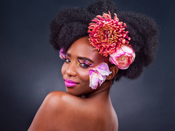 Im about to turn some heads. Studio shot of a beautiful young woman posing with flowers in her hair - Fotó, kép