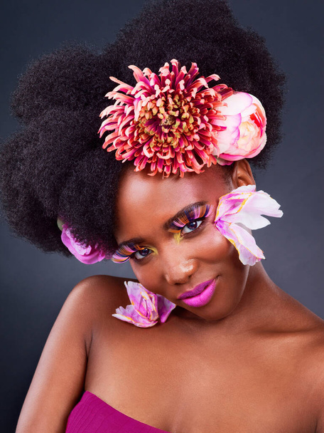 Nothing is prettier than a woman in pink. Studio shot of a beautiful young woman posing with flowers in her hair - Foto, imagen