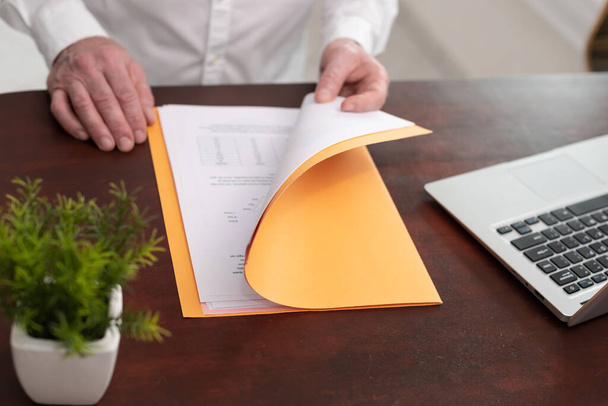Бизнесмен открывает папку с бумажными документами - Фото, изображение