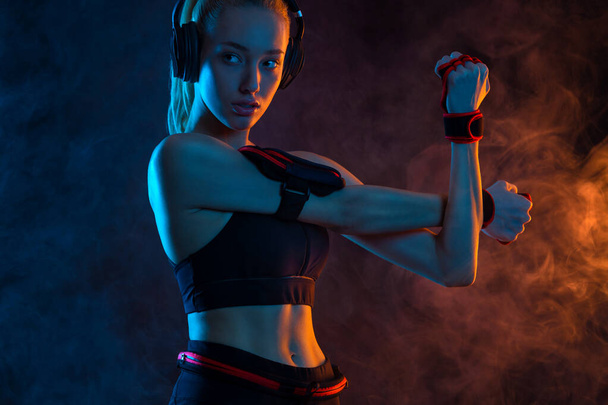 Strong athletic fit woman on black background wearing in the sportswear. Fitness and sport motivation - Photo, image