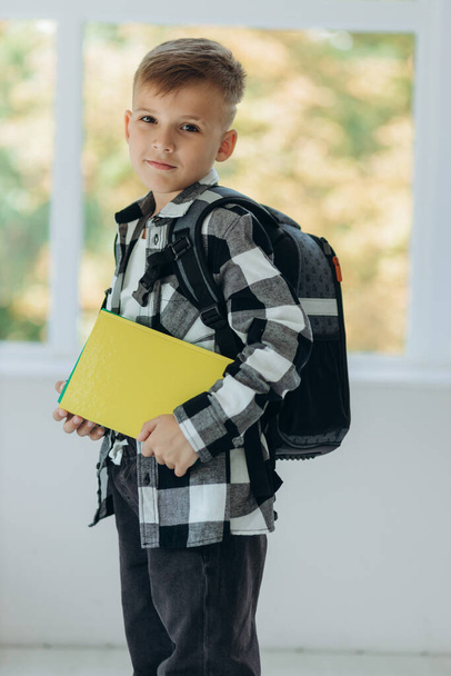 Улыбающийся подросток с портфелем и блокнотами. Портрет студента-подростка - Фото, изображение