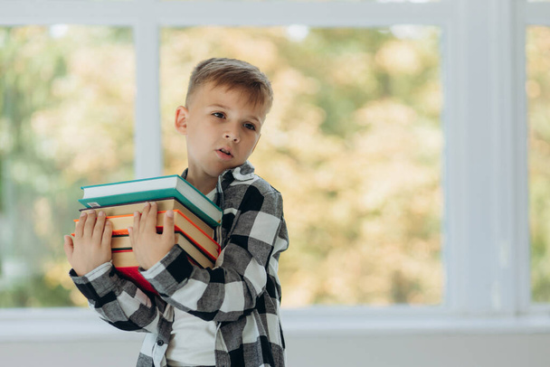 Портрет счастливого школьника с книгой в руке. Первый раз в школе. Возвращение в школу. - Фото, изображение