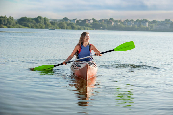 girl rowing a kayak on the lake. A girl in a canoe on a water excursion, active pastime - Foto, Imagem