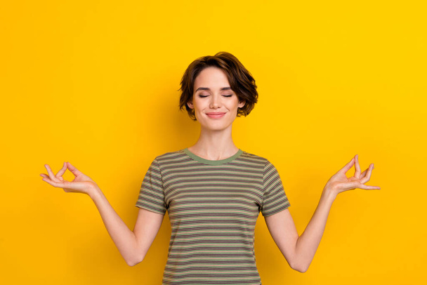 Photo of dreamy funny lady wear striped t-shirt smiling practicing yoga isolated yellow color background. - Фото, зображення