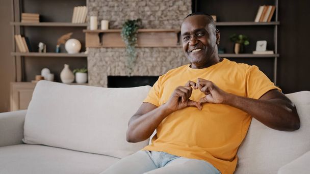 African affectionate lover man gentle american adult senior volunteer make heart shape with fingers expressing healthy human feels charity love romantic valentine symbol for beloved sweetheart at home - 写真・画像