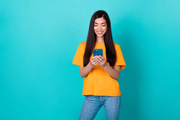 Photo of cute millennial lady write telephone wear orange t-shirt isolated on teal color background. - Photo, Image