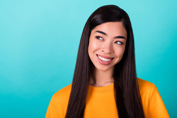 Photo of gorgeous good mood girl with straight hairstyle dressed yellow t-shirt look at empty space isolated on turquoise color background. - Φωτογραφία, εικόνα