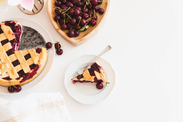 Plate with tasty American cherry pie on white background. Top view. Copy space - Zdjęcie, obraz
