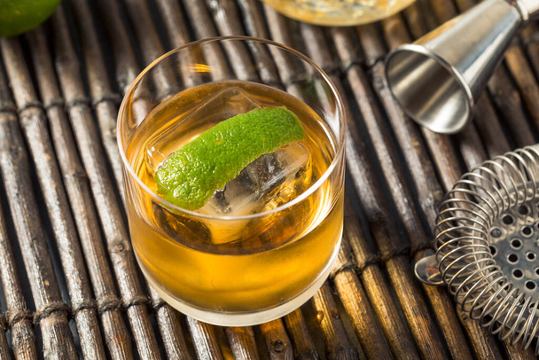 Boozy Cold Rum Old Fashioned with Lime and an Ice Cube - 写真・画像