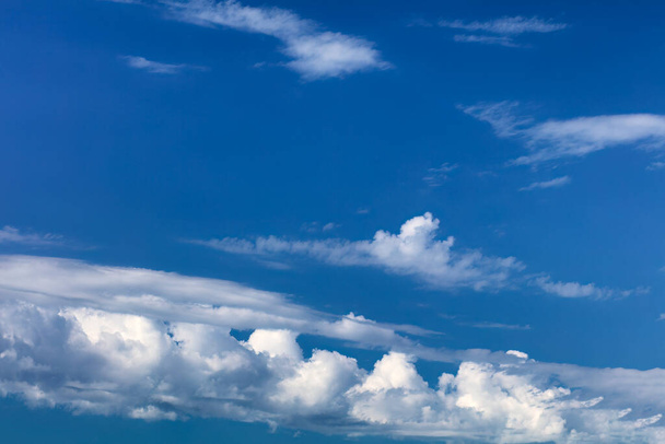 Небо на фоне темно-синего неба и белых облаков  - Фото, изображение