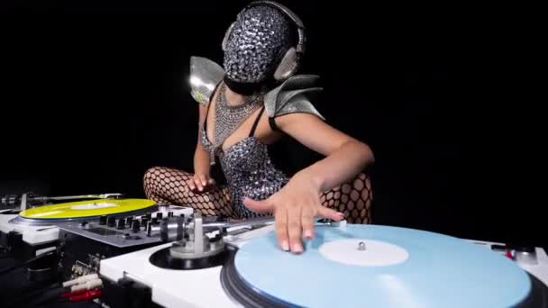 Beautiful female dj playing with turntables in sparkling silver costume - Felvétel, videó