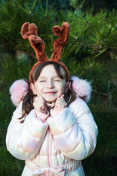  girl in a winter park,smiling girl with deer ears in the forest has fun - Photo, image