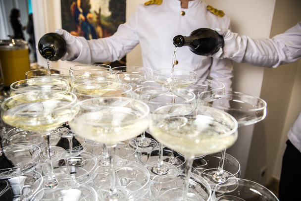 Catering. Waiters pouring champagne into wineglasses - Photo, Image