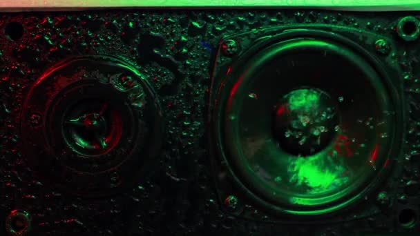 Musical speaker in water drops with beautiful colored backlight multicolored wet Musical speaker close-up. Lighting to the beat of the music. High quality FullHD footage - Video