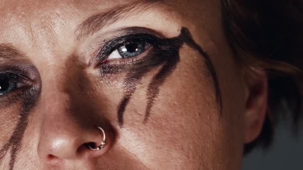 Melancholic woman with black eye make-up looking - Video