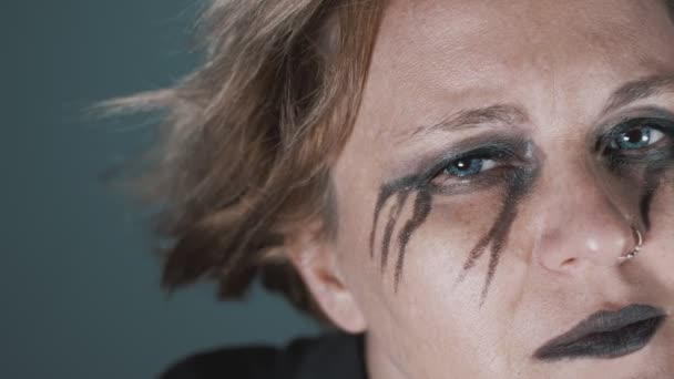 Melancholic woman with black eye make-up looking - Filmati, video
