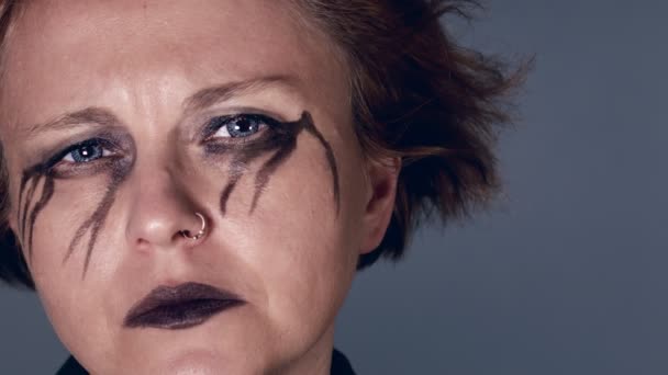 Melancholic woman with black eye make-up looking - Filmati, video