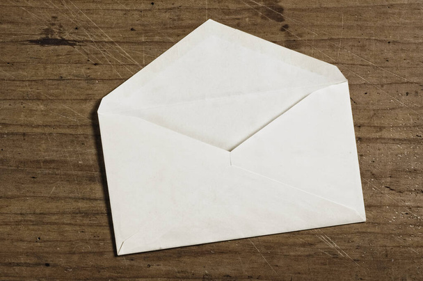 White envelope on wooden table, open, studio shot. - Foto, imagen