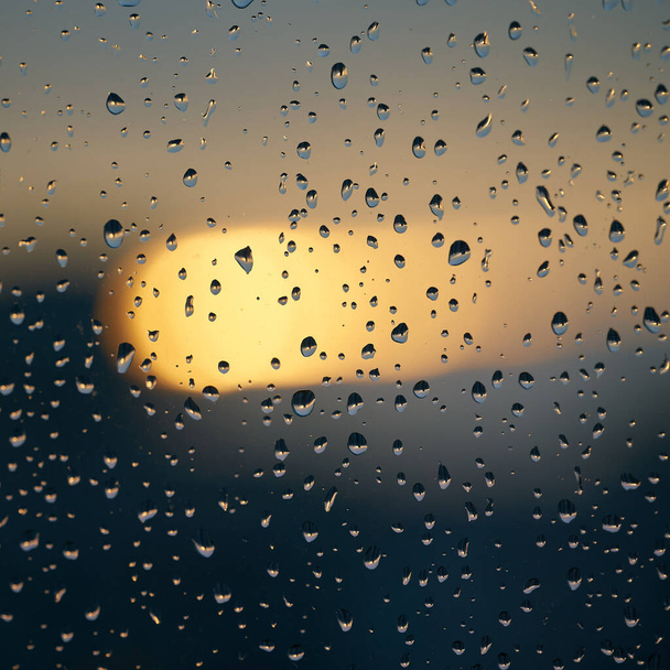  Σταγόνες βροχής σε ένα παράθυρο μετά από μια βροχή στο ηλιοβασίλεμα                               - Φωτογραφία, εικόνα