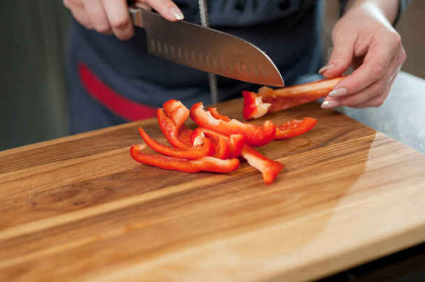 The cook cuts vegetables with a knife to prepare the dish. Cutting vegetables. - Foto, imagen