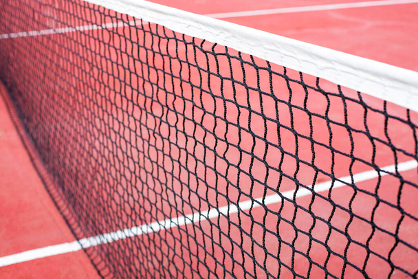 The tennis net on the background of the court is red. The theme of sports and a healthy lifestyle. Close-up image. - Φωτογραφία, εικόνα