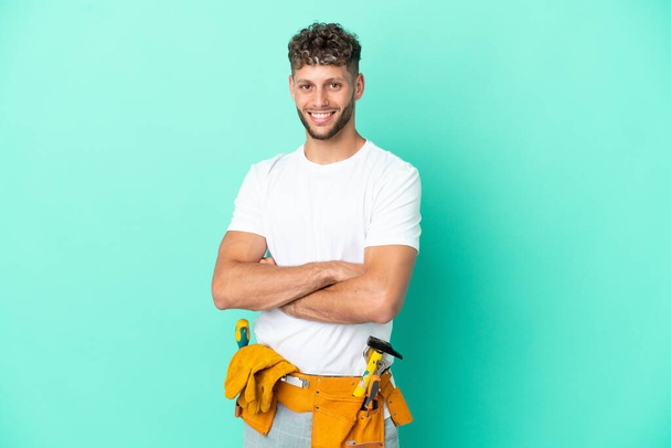 Young electrician blonde man isolated on green background with arms crossed and looking forward - Fotografie, Obrázek