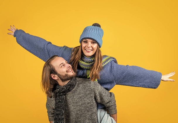 She is the love of his life. Happy boyfriend carry girlfriend piggyback. Romantic love. Loving couple yellow background. Man and woman have fun. Sweethearts. - Zdjęcie, obraz