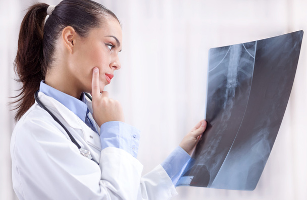beautiful young woman orthopedist examine X-rays - Фото, изображение