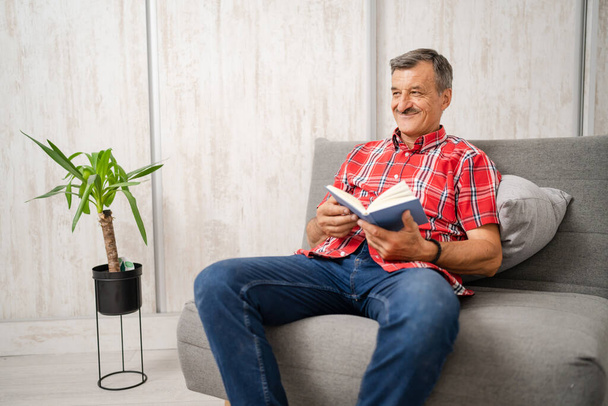 One man senior caucasian male with mustaches read book at home wear red shirt real people leisure concept copy space - Photo, Image